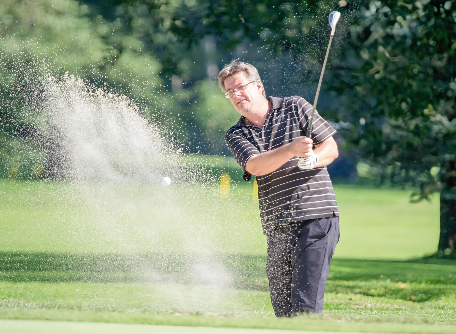 Schlag eines Golfers aus dem Bunker